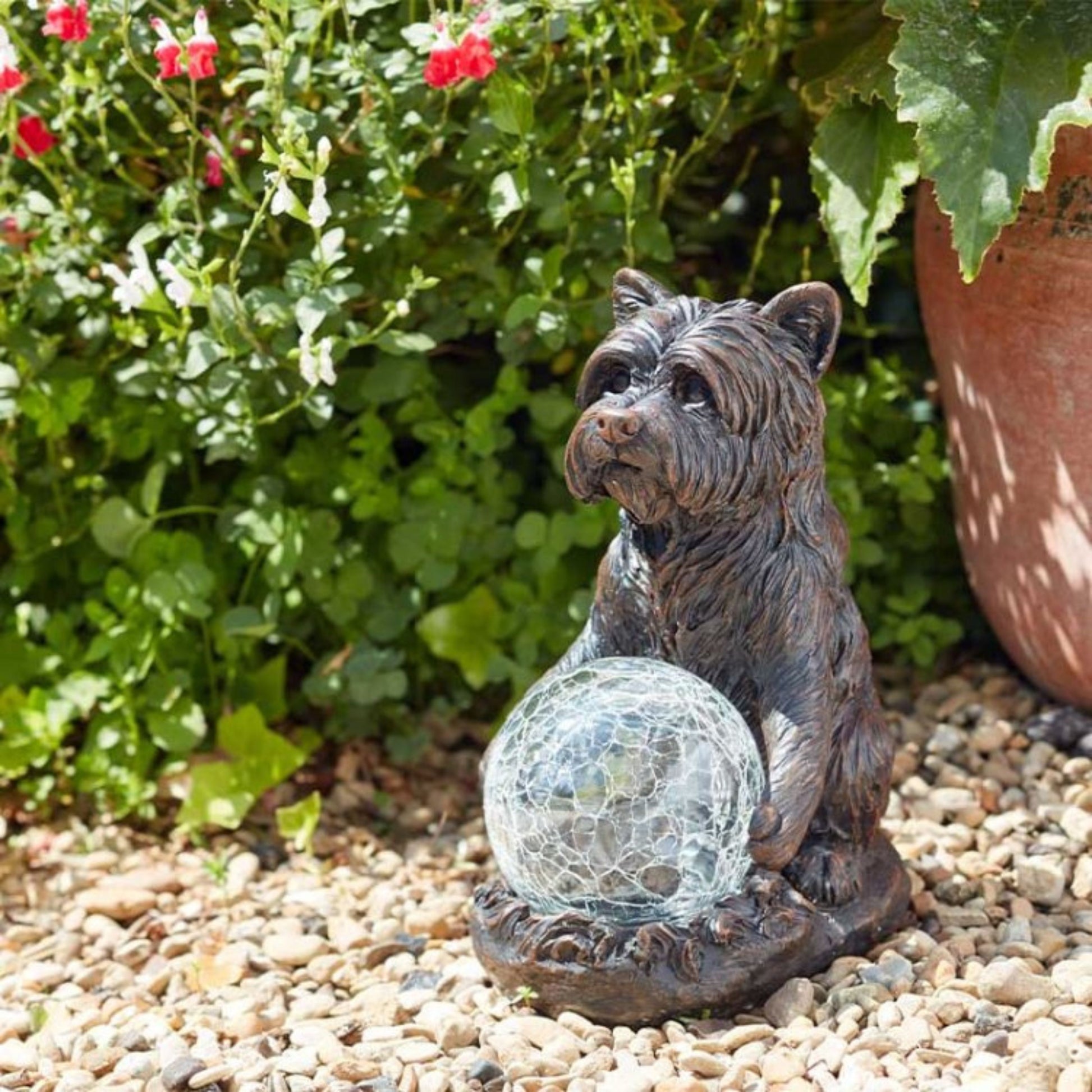 dog figurine holding solar ball during day light