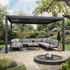 Outdoor patio with sectional sofa, table under a pergola.