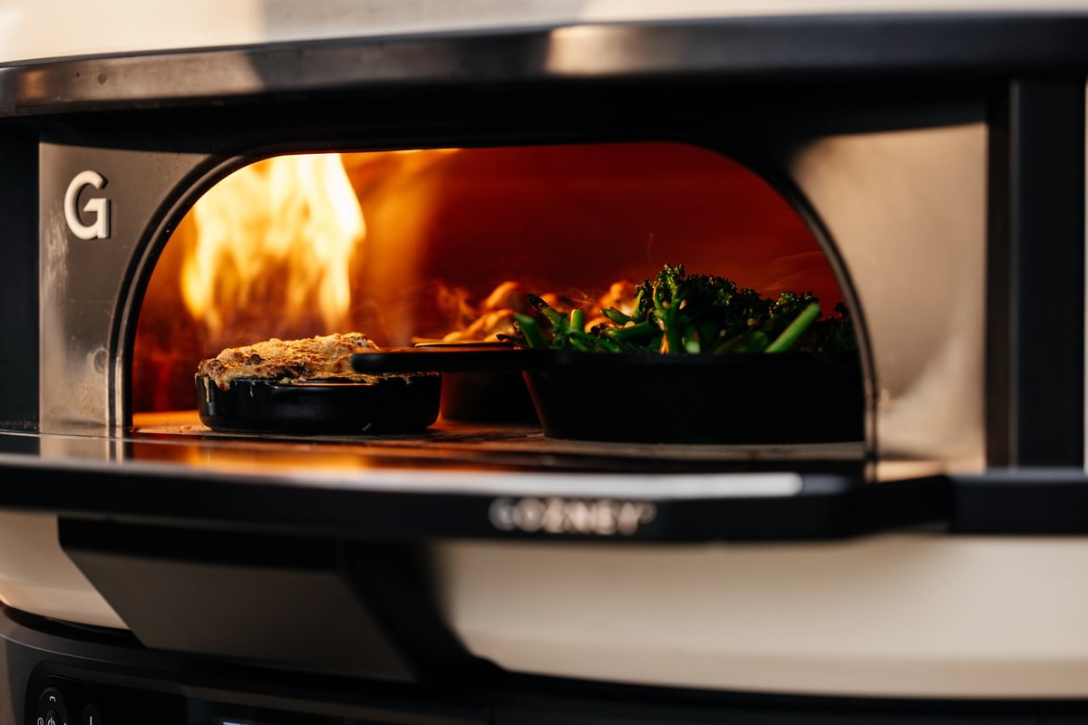 Wood-fired pizza oven with food being cooked inside